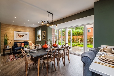Open plan kitchen with dining table and French doors showing the garden